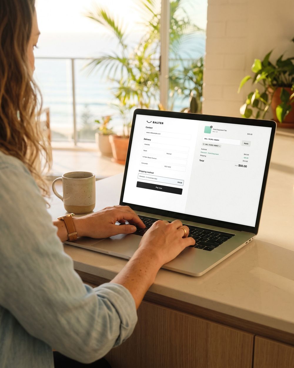 Sarah's laptop shows the Balter store checkout with her Club Enjoyment code applied